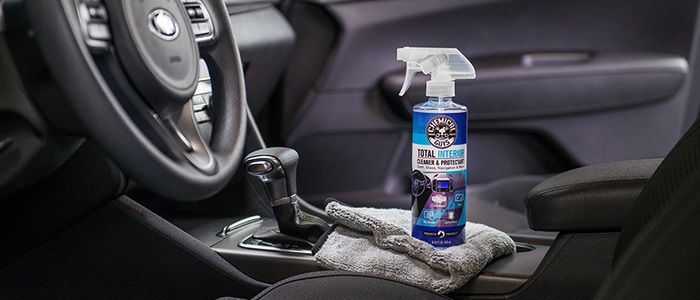 Pulverización de detergente en el salpicadero del interior del coche para  la limpieza en seco el limpiador profesional con guantes vierte detergente  en el coche para eliminar las manchas y la suciedad